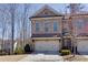 Charming brick townhome featuring a two-car garage, well-maintained landscaping, and classic architectural details at 2006 Towneship Trl, Roswell, GA 30075