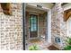 Inviting front entrance with a brick facade, decorative lanterns, and 'welcome home' mat at 2006 Towneship Trl, Roswell, GA 30075