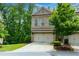 Attractive brick townhome featuring a two-car garage and nicely landscaped front yard at 2006 Towneship Trl, Roswell, GA 30075