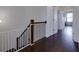 Upstairs hallway with dark hardwood flooring and white trim, featuring a secure baby gate at 2006 Towneship Trl, Roswell, GA 30075