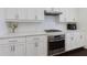 Close up of well-appointed kitchen with stainless steel oven, cooktop, and white shaker-style cabinets at 2006 Towneship Trl, Roswell, GA 30075