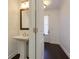 Stylish powder room featuring a pedestal sink, decorative mirror, and convenient access to the entryway at 2006 Towneship Trl, Roswell, GA 30075