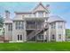 Backyard view of a home with a two-story deck, lower patio, and a stone fireplace feature at 414 Candler Trl, Canton, GA 30115