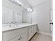 Bright bathroom featuring a double vanity, large mirror, and tile floor at 414 Candler Trl, Canton, GA 30115