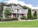 Attractive brick home with a covered porch and manicured hedges, set on a lush green lawn at 414 Candler Trl, Canton, GA 30115
