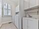 Clean and functional laundry room with white cabinets, sink, and a window for natural light at 414 Candler Trl, Canton, GA 30115