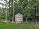 A charming storage shed nestled among mature trees and lush green grass provides convenient outdoor storage at 414 Candler Trl, Canton, GA 30115