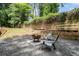 Backyard patio area with pea gravel, wooden fence, and a rustic fire pit perfect for outdoor gatherings at 4469 Huntington Cir, Atlanta, GA 30338