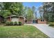 Charming brick home featuring a well-manicured lawn and a long driveway in a serene, wooded setting at 4469 Huntington Cir, Atlanta, GA 30338