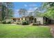 Exterior back view of home with a large, grassy lawn and tiered deck at 4469 Huntington Cir, Atlanta, GA 30338