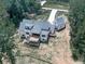 Rear aerial view of a modern home featuring a spacious deck and surrounded by a backdrop of dense trees at 106 Belmont Dr, Canton, GA 30115