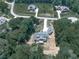 The aerial view displays a large home with deck nestled within a lush wooded area, surrounded by other residences at 106 Belmont Dr, Canton, GA 30115