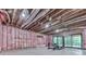 Unfinished basement featuring pink insulated walls, exposed ceiling, and sliding glass doors at 106 Belmont Dr, Canton, GA 30115