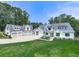 Stunning white farmhouse-style home with a spacious lawn, and a five-car garage nestled among mature trees at 106 Belmont Dr, Canton, GA 30115