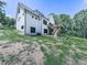 Side view of the house showcasing the deck, stairs, and outdoor space against a lush green backdrop at 106 Belmont Dr, Canton, GA 30115