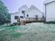 Rear exterior view of a modern farmhouse with a wooden deck and manicured lawn at 106 Belmont Dr, Canton, GA 30115
