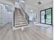 Elegant foyer with modern staircase, black-framed door, and light hardwood flooring at 106 Belmont Dr, Canton, GA 30115