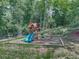 Backyard playground area featuring a wooden playset with swings, slide, and playhouse surrounded by trees at 106 Belmont Dr, Canton, GA 30115
