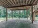 View of the open space under the deck, providing a shaded area with a concrete foundation and wooded scenery at 106 Belmont Dr, Canton, GA 30115