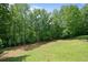 Lush backyard with tall trees and grass, offering privacy and a connection to nature at 1758 Rosehedge Nw Way, Kennesaw, GA 30152