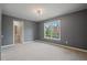 Well-lit bedroom with neutral carpeting, gray paint, large window and adjoining bathroom at 1758 Rosehedge Nw Way, Kennesaw, GA 30152