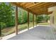Covered patio with wooden support beams overlooking a grass backyard surrounded by lush trees at 1758 Rosehedge Nw Way, Kennesaw, GA 30152