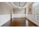 Dining room featuring wainscoting, hardwood floors, a tray ceiling, and plantation shutters at 1758 Rosehedge Nw Way, Kennesaw, GA 30152