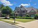 Beautiful brick home with manicured lawn and mature landscaping, complemented by a clear blue sky at 1758 Rosehedge Nw Way, Kennesaw, GA 30152