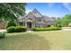 Beautiful brick home with manicured lawn, lush shrubbery, and a covered front porch exudes curb appeal at 1758 Rosehedge Nw Way, Kennesaw, GA 30152