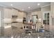 This open-concept kitchen is outfitted with granite counters, stainless appliances, and custom cabinets at 1758 Rosehedge Nw Way, Kennesaw, GA 30152