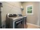 Efficient laundry room includes front loading washer and dryer plus storage shelving and window at 1758 Rosehedge Nw Way, Kennesaw, GA 30152