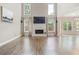 Open living room with tall ceilings, hardwood floors, a fireplace, and plenty of natural light at 1758 Rosehedge Nw Way, Kennesaw, GA 30152