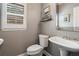 Stylish powder room with a pedestal sink, decorative mirror, and window with plantation shutters at 1758 Rosehedge Nw Way, Kennesaw, GA 30152