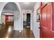 Inviting entryway featuring hardwood floors, arched doorways, and a striking red front door at 230 King Arthur Dr, Woodstock, GA 30189