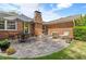 Brick home with a stone patio featuring an outdoor dining and seating area for entertaining at 2785 Fontainebleau Dr, Dunwoody, GA 30360
