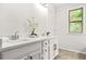 Bright bathroom features double sinks, white cabinets, and a window at 6571 Splitpine Ct, Atlanta, GA 30349