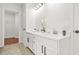 Bright bathroom featuring double sink vanity with white cabinets, black hardware, and white quartz countertops at 6571 Splitpine Ct, Atlanta, GA 30349
