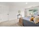 Bright bedroom featuring a window view, a side table, a reading chair, and modern decor at 6571 Splitpine Ct, Atlanta, GA 30349