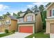 Two-story home features a red garage door, green trim, and is set on a well-manicured lawn at 6571 Splitpine Ct, Atlanta, GA 30349