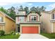 Charming two-story home boasts a red garage door, green trim and a well-manicured lawn at 6571 Splitpine Ct, Atlanta, GA 30349