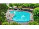 Community pool surrounded by lush landscaping, chairs, and secure fencing at 6571 Splitpine Ct, Atlanta, GA 30349