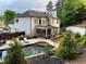 Spacious backyard with a pristine pool, stone patio, and lush landscaping, great for outdoor living at 970 Tarpley Nw Rd, Kennesaw, GA 30152