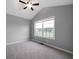 This is a bedroom with neutral walls, carpet, and a large window overlooking the front yard at 137 Cambridge Pointe, Villa Rica, GA 30180