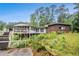 Backyard view features a large deck, overgrown landscaping, and a serene setting at 2549 Emerald Dr, Jonesboro, GA 30236