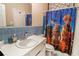 Bathroom with a blue tiled wall, white sink, toilet and anime themed curtain at 2549 Emerald Dr, Jonesboro, GA 30236