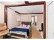 Bedroom with a wooden beam ceiling, bed, chair, and open doorway at 2549 Emerald Dr, Jonesboro, GA 30236