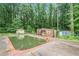 Backyard view showcasing an in-ground pool surrounded by a brick border and featuring small outbuildings at 2549 Emerald Dr, Jonesboro, GA 30236