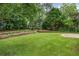 Sprawling backyard with terraced landscaping, a paver patio, mature trees and lush grass at 3019 Haverford Se Ln, Marietta, GA 30067