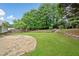 Grassy backyard featuring a brick patio, mature trees and landscaping at 3019 Haverford Se Ln, Marietta, GA 30067