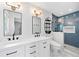 Elegant bathroom featuring double sink vanity, black fixtures, and glass enclosed shower with blue tiling at 3019 Haverford Se Ln, Marietta, GA 30067